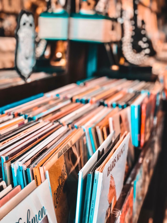 Close-up of colorful books lined up on a wooden shelf in a vibrant library setting.